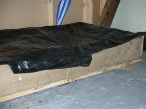 worm bin covered with black plastic